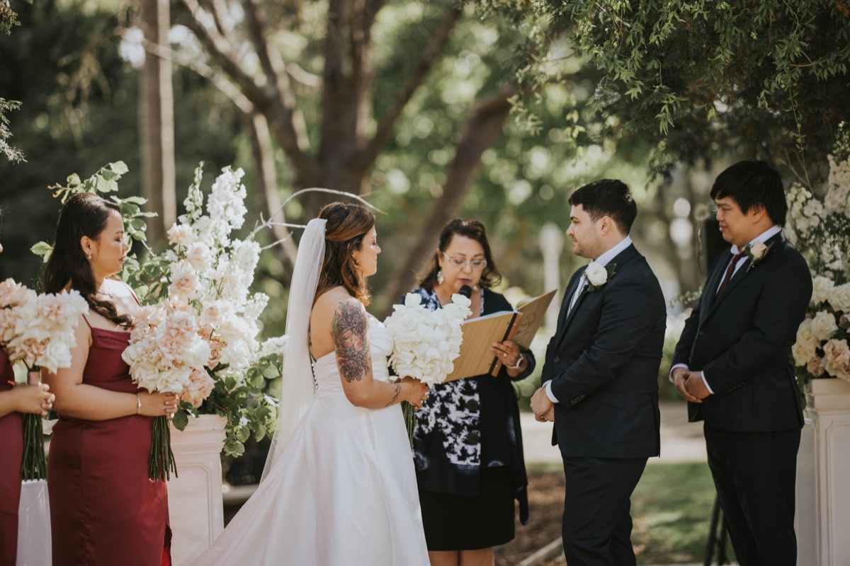 Josephine reading a couple's ceremony to them under the trees