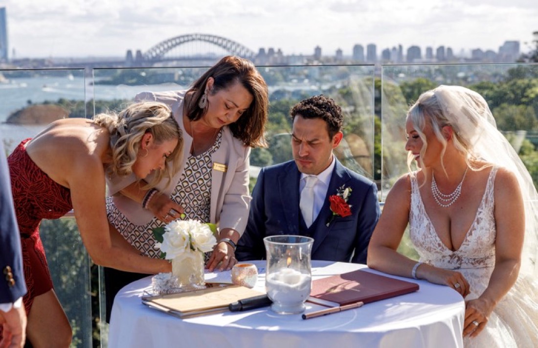 Josephine signing the register with a couple on the harbour