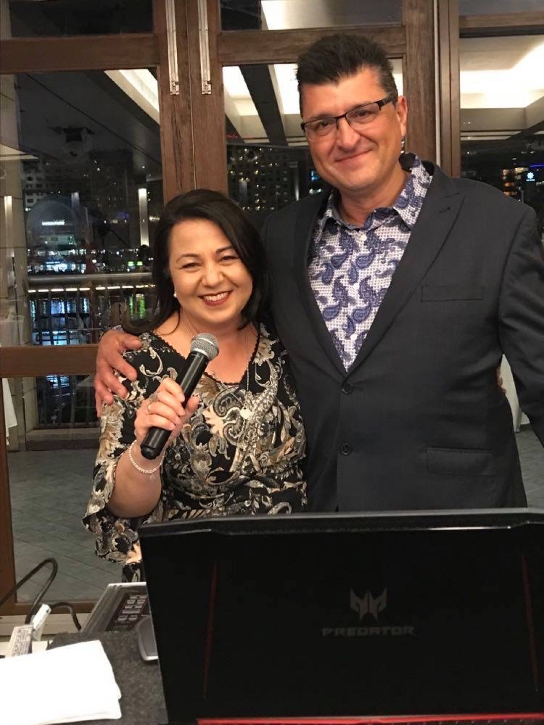 Josephine hosting as master of ceremonies with a microphone at a reception